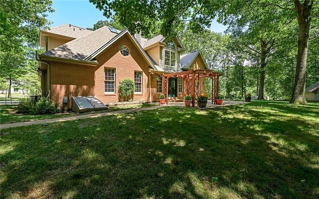 103 Mcdonnell Ln, Middlesex Twp, PA 16002 - back of house featuring brick siding, a pergola, a lawn, and a shingled roof