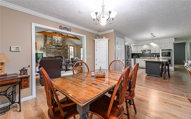 133 Miller Rd, Clinton Twp, PA 16055 - dining space with a textured ceiling, a stone fireplace, light wood-type flooring, a chandelier, and ornamental molding