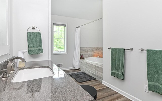 133 Miller Rd, Clinton Twp, PA 16055 - full bath with tiled bath, a sink, wood finished floors, curtained shower, and baseboards