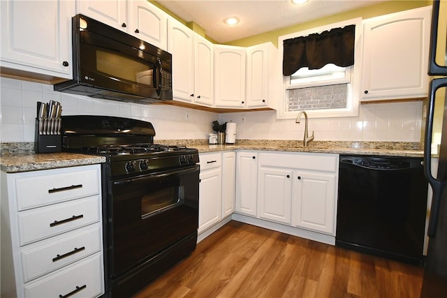 1312 Kelton Ave, Dormont, PA 15216 - kitchen with black appliances, a sink, dark wood finished floors, light stone countertops, and white cabinetry