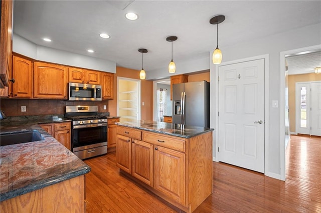 115 Tartan Dr, Hempfield Twp Wml, PA 15601 - kitchen featuring stainless steel appliances, a sink, a center island, brown cabinets, and wood finished floors