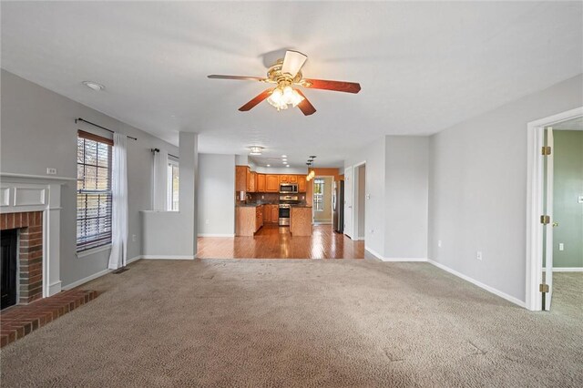 115 Tartan Dr, Hempfield Twp Wml, PA 15601 - unfurnished living room featuring light carpet, a fireplace, ceiling fan, and baseboards