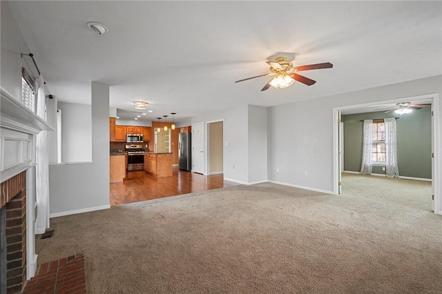 115 Tartan Dr, Hempfield Twp Wml, PA 15601 - unfurnished living room with carpet flooring, ceiling fan, a fireplace, and baseboards