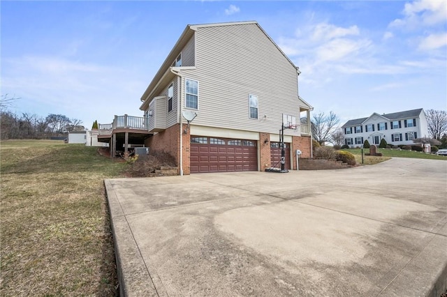 115 Tartan Dr, Hempfield Twp Wml, PA 15601 - view of home's exterior featuring brick siding, driveway, a garage, a lawn, and a deck