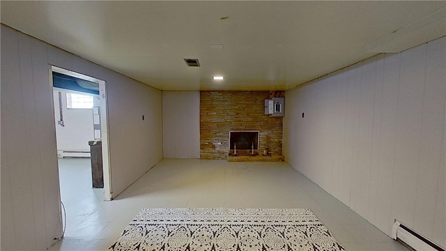 122 Burke Dr, Monroeville, PA 15146 - unfurnished living room with a baseboard heating unit, light flooring, a baseboard radiator, a fireplace, and wood walls