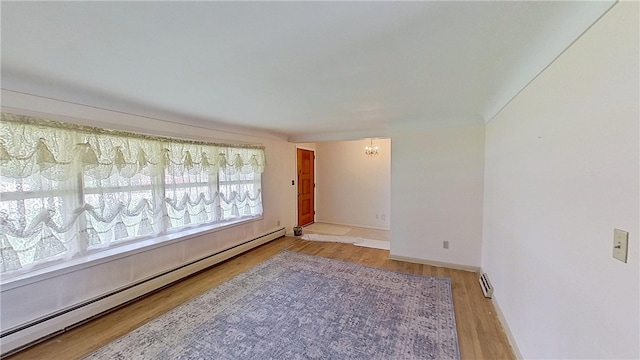 122 Burke Dr, Monroeville, PA 15146 - spare room featuring a baseboard radiator, a chandelier, wood finished floors, and baseboards