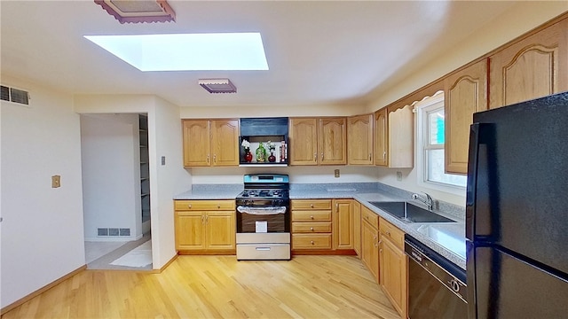 122 Burke Dr, Monroeville, PA 15146 - kitchen with freestanding refrigerator, stainless steel gas range oven, dishwashing machine, a sink, and a skylight