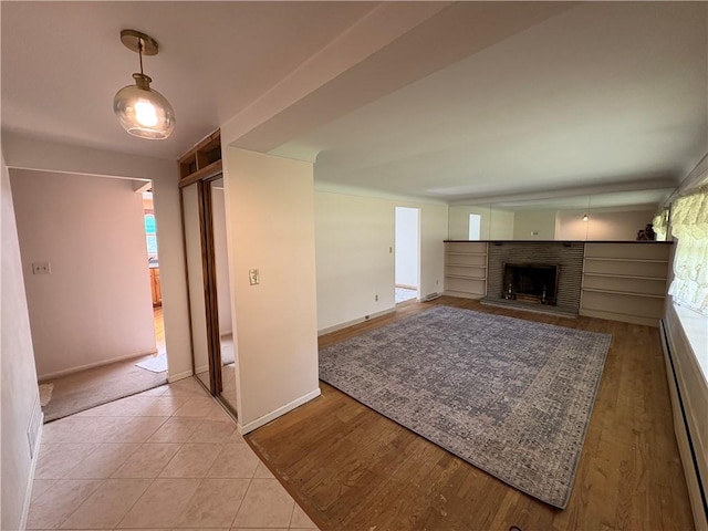 122 Burke Dr, Monroeville, PA 15146 - unfurnished living room with baseboard heating, a fireplace, baseboards, and plenty of natural light
