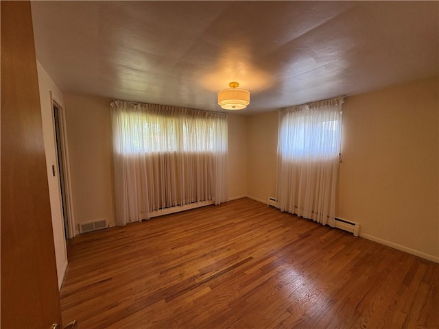 122 Burke Dr, Monroeville, PA 15146 - unfurnished room with plenty of natural light, wood finished floors, baseboards, and a baseboard heating unit