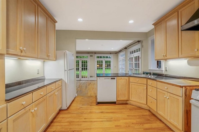 1167 Murray Hill Ave, Squirrel Hill, PA 15217 - kitchen featuring white appliances, light wood-type flooring, wall chimney exhaust hood, light brown cabinetry, and a peninsula