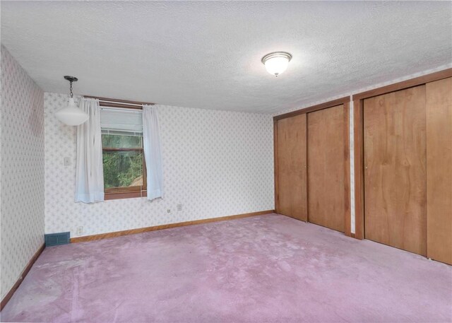 2555 Cole Rd, Marshall, PA 15090 - unfurnished bedroom featuring multiple closets, a textured ceiling, carpet flooring, and wallpapered walls