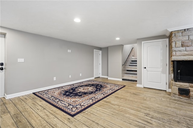 1182 W Laurel Cir, Mount Pleasant Twp, PA 15666 - unfurnished living room with a large fireplace, stairs, baseboards, light wood-type flooring, and recessed lighting