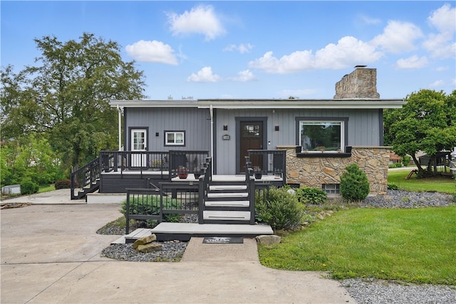 1182 W Laurel Cir, Mount Pleasant Twp, PA 15666 - view of front of home with a chimney, a deck, stairs, and stone siding