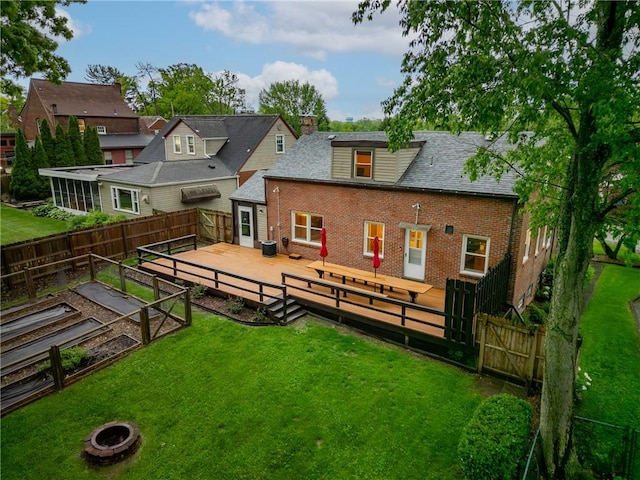 132 Crescent Hills Rd, Penn Hills, PA 15235 - back of property with brick siding, an outdoor fire pit, a vegetable garden, a deck, and a chimney