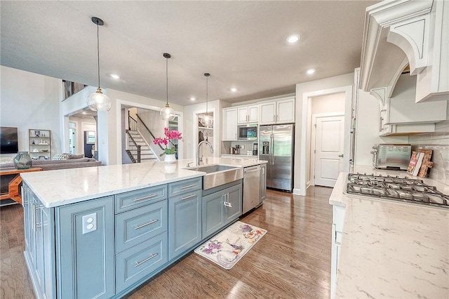 1703 Stevensan, Franklin Park, PA 15143 - kitchen with appliances with stainless steel finishes, a sink, white cabinetry, wood finished floors, and a kitchen island with sink