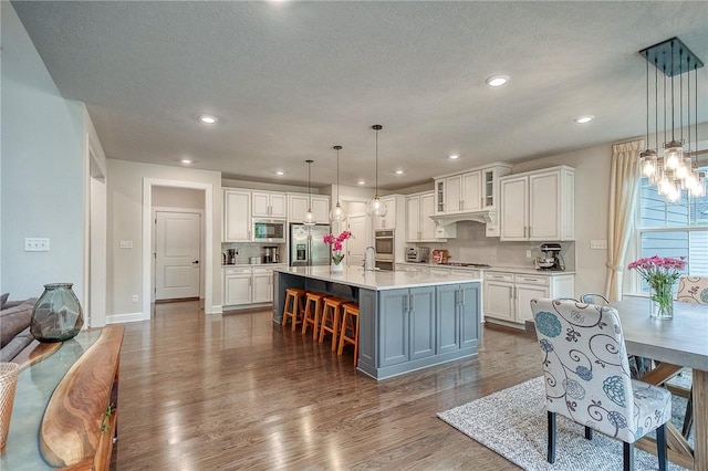 1703 Stevensan, Franklin Park, PA 15143 - kitchen with stainless steel appliances, white cabinetry, dark wood finished floors, light countertops, and a breakfast bar