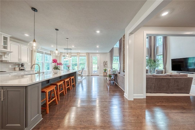 1703 Stevensan, Franklin Park, PA 15143 - kitchen featuring open floor plan, gray cabinets, a sink, dark wood-style floors, and a breakfast bar