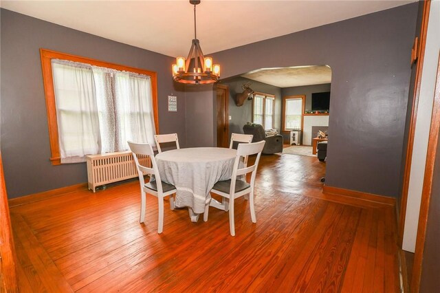 1778 Mercer Rd, Lake Twp, PA 16133 - dining space with arched walkways, a chandelier, radiator, wood finished floors, and baseboards