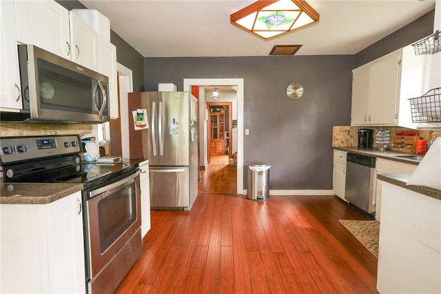 1778 Mercer Rd, Lake Twp, PA 16133 - kitchen featuring appliances with stainless steel finishes, backsplash, white cabinets, dark countertops, and hardwood / wood-style floors