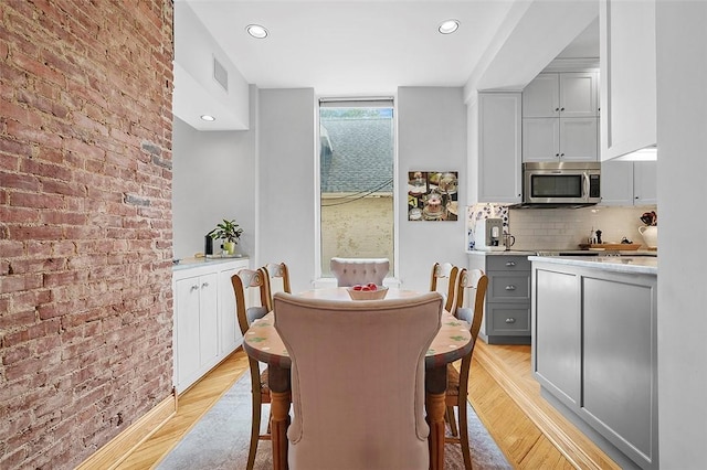 6015 Walnut St Unit 201, Shadyside, PA 15206 - dining space with light wood finished floors, recessed lighting, and brick wall