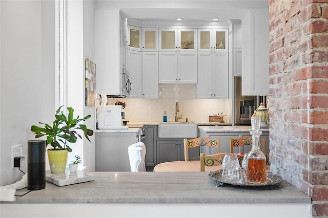 6015 Walnut St Unit 201, Shadyside, PA 15206 - kitchen with a sink, stainless steel microwave, white cabinetry, glass insert cabinets, and backsplash