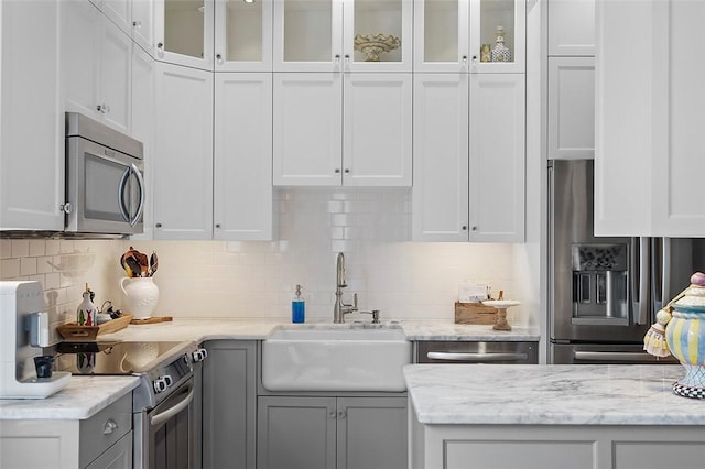 6015 Walnut St Unit 201, Shadyside, PA 15206 - kitchen with stainless steel appliances, a sink, white cabinetry, and backsplash