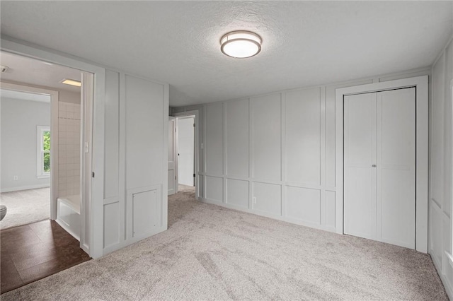 1218 W Ridge Ave, Sharpsville, PA 16150 - unfurnished bedroom featuring a decorative wall, carpet flooring, a textured ceiling, and a closet