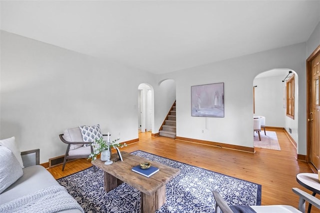61 Ehle Ave, Kennedy Twp, PA 15108 - living area featuring arched walkways, stairway, light wood-type flooring, and baseboards