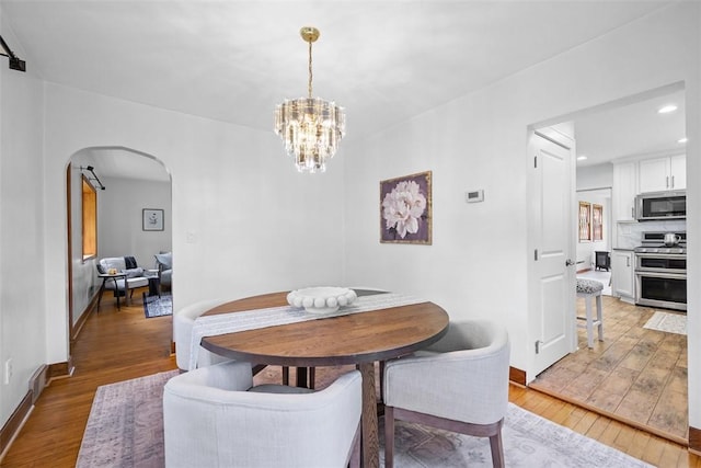 61 Ehle Ave, Kennedy Twp, PA 15108 - dining room with arched walkways, light wood-type flooring, a chandelier, recessed lighting, and baseboards