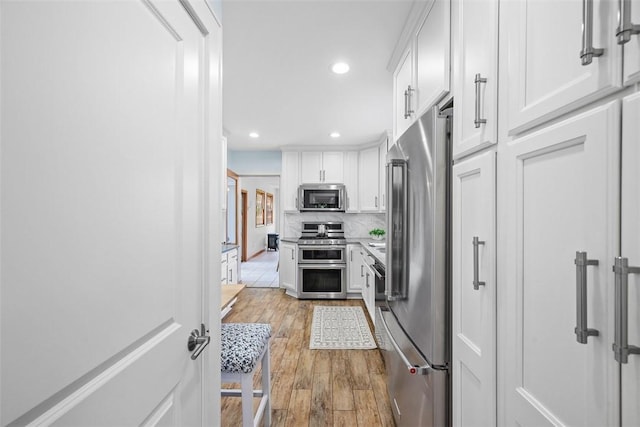 61 Ehle Ave, Kennedy Twp, PA 15108 - kitchen with appliances with stainless steel finishes, white cabinetry, light wood-type flooring, recessed lighting, and tasteful backsplash