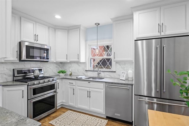 61 Ehle Ave, Kennedy Twp, PA 15108 - kitchen with stainless steel appliances, a sink, light stone countertops, light wood-type flooring, and recessed lighting