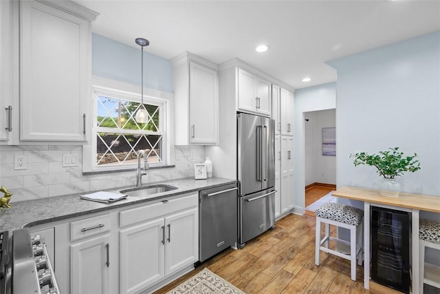 61 Ehle Ave, Kennedy Twp, PA 15108 - kitchen with stainless steel appliances, beverage cooler, a sink, white cabinetry, and decorative backsplash