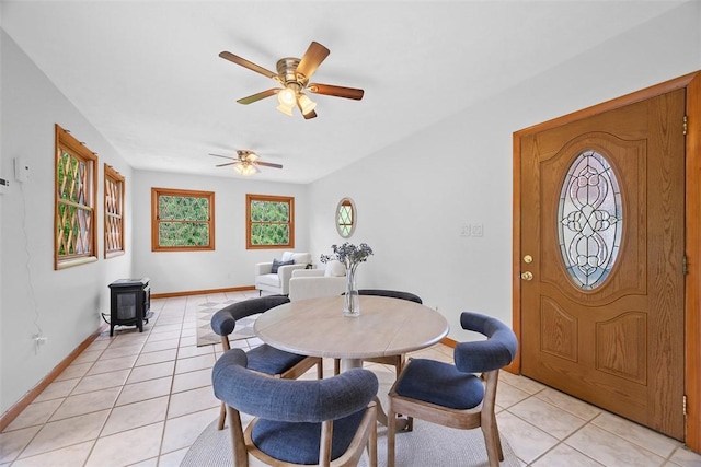61 Ehle Ave, Kennedy Twp, PA 15108 - dining area with a wood stove, light tile patterned flooring, a ceiling fan, and baseboards