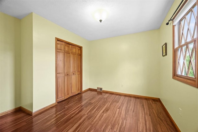 61 Ehle Ave, Kennedy Twp, PA 15108 - unfurnished bedroom featuring dark wood-type flooring, baseboards, and a closet
