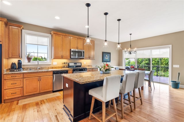 209 Lucca Ln, Upper St Clair, PA 15241 - kitchen featuring stainless steel appliances, a sink, a center island, light wood-style floors, and a kitchen bar
