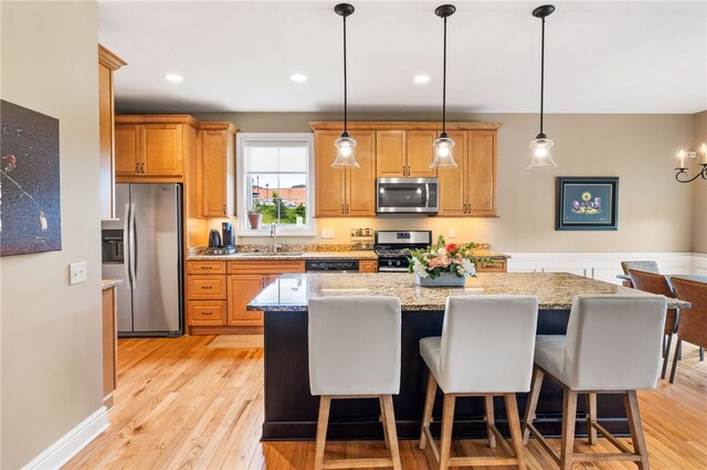 209 Lucca Ln, Upper St Clair, PA 15241 - kitchen featuring stainless steel appliances, a sink, a kitchen island, light wood finished floors, and hanging light fixtures