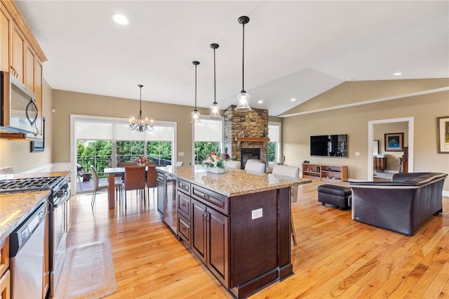 209 Lucca Ln, Upper St Clair, PA 15241 - kitchen with appliances with stainless steel finishes, light wood-style flooring, open floor plan, a stone fireplace, and a chandelier