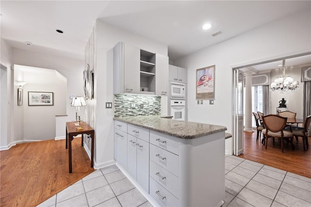 202 N Woodland Rd, Shadyside, PA 15232 - kitchen with white appliances, open shelves, light tile patterned floors, a peninsula, and white cabinetry
