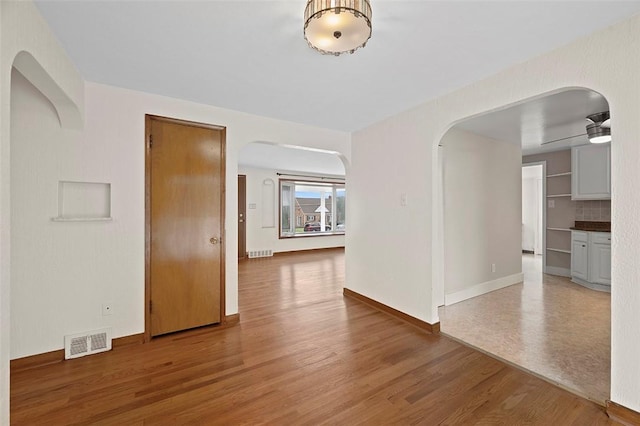 3353 Mcroberts Rd, Castle Shannon, PA 15234 - empty room featuring arched walkways, wood finished floors, baseboards, and ceiling fan