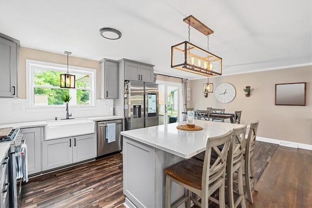 6003 Kingston Dr, Hopewell Twp Bea, PA 15001 - kitchen featuring appliances with stainless steel finishes, a sink, gray cabinets, dark wood-style floors, and ornamental molding