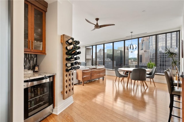 151 Fort Pitt Blvd Unit 1703, Downtown Pgh, PA 15222 - dining space with wine cooler, light wood-type flooring, a dry bar, a view of city, and baseboards