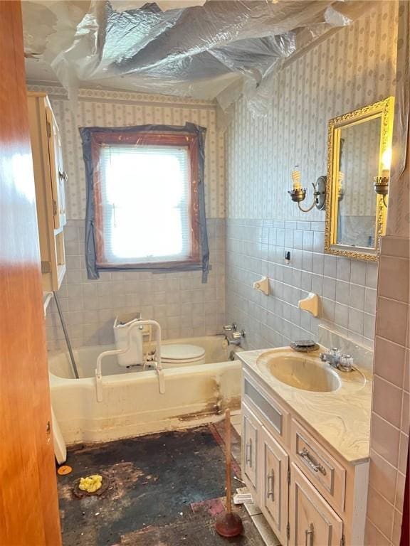 256 Vermont St, Hempfield Twp Wml, PA 15601 - full bath with a tub to relax in, vanity, tile walls, wallpapered walls, and a wainscoted wall