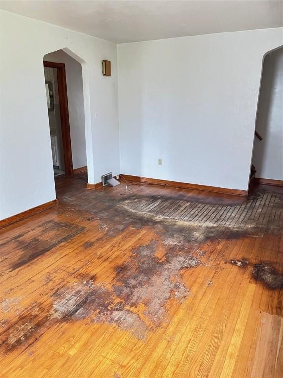256 Vermont St, Hempfield Twp Wml, PA 15601 - empty room with wood-type flooring, arched walkways, and baseboards