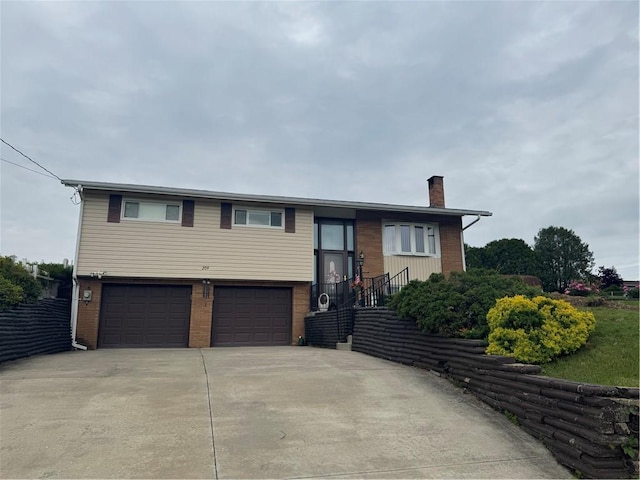 209 Pawnee St, Rostraver, PA 15012 - raised ranch featuring a chimney, an attached garage, concrete driveway, and brick siding