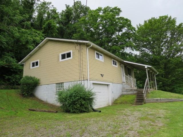 21 Daisytown Rd, W Pike Run Twp, PA 15427 - view of side of property featuring an attached garage, stairs, and a lawn