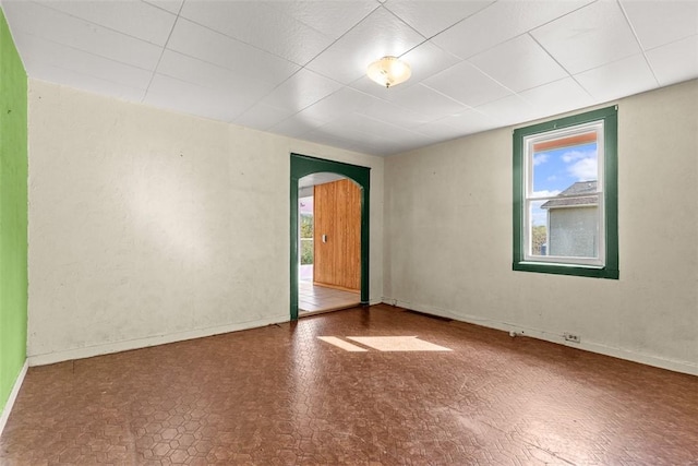 1458 Isoline, Sheraden, PA 15204 - empty room featuring arched walkways, healthy amount of natural light, baseboards, and a drop ceiling