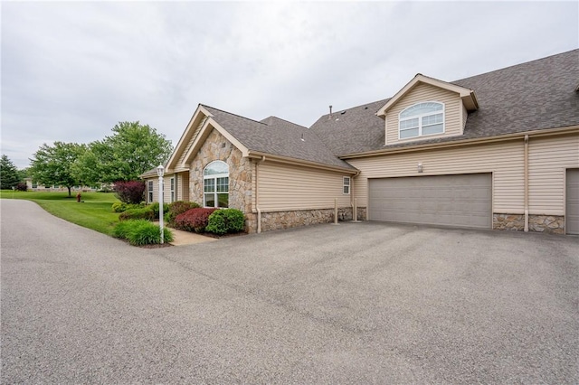6055 Triple Crown Cir, Hempfield Twp Wml, PA 15601 - view of property exterior featuring stone siding, driveway, an attached garage, and a shingled roof