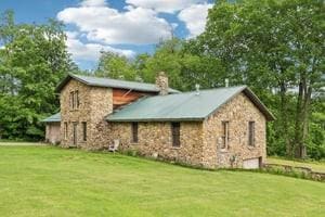 929 Al Smith Dr, Kennedy Twp, PA 15136 - view of side of home featuring stone siding, a lawn, a chimney, and a garage