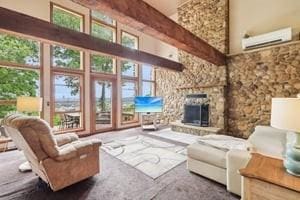 929 Al Smith Dr, Kennedy Twp, PA 15136 - living area featuring healthy amount of natural light, a towering ceiling, and a stone fireplace