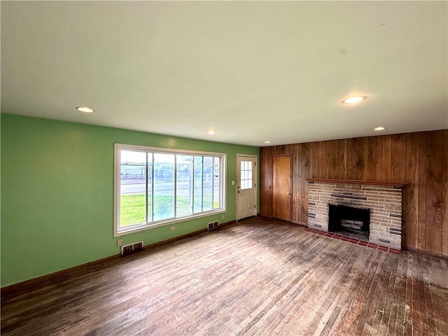 3406 New Castle, West Middlesex Boro, PA 16159 - unfurnished living room with wood finished floors, recessed lighting, a brick fireplace, wooden walls, and baseboards